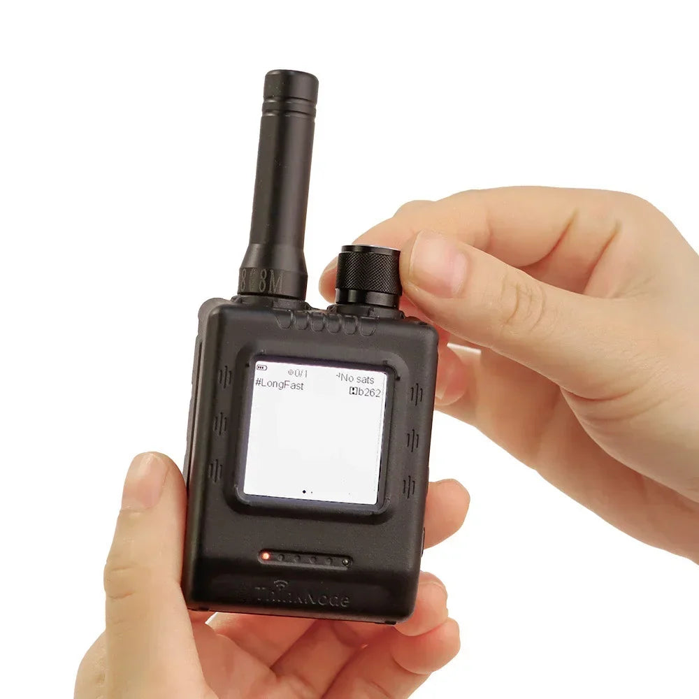 Hand holding a black LoRa walkie talkie transceiver with display and antenna